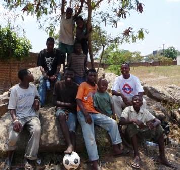 the boys sitting under the shade of a tree